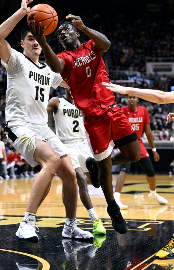 A Nicholls State player shoots the ball past Zach Edey.